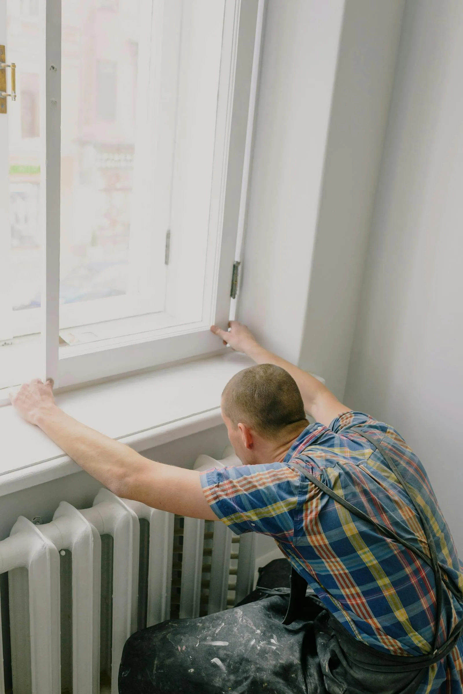 Contractor installing a window during a home renovation